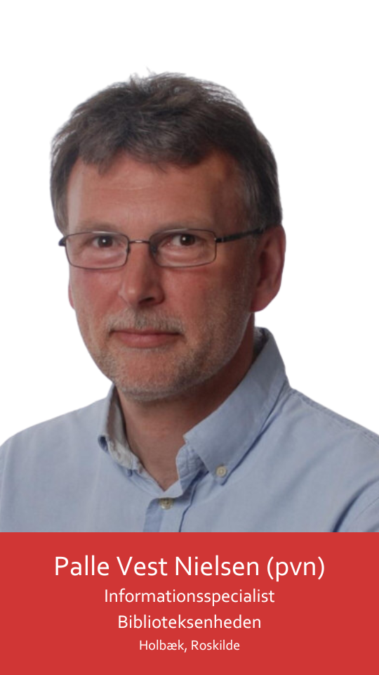 Dette billede viser en midaldrende mand iført sorte briller og en lyseblå skjorte. Han ser direkte på kameraet med et tilfreds udtryk og smiler let. Hans hår er kort, mørkt og gråplettet brunt. Hans hage er let hævet, mens han ser ind i kameralinsen, hvilket giver ham et selvsikkert blik.